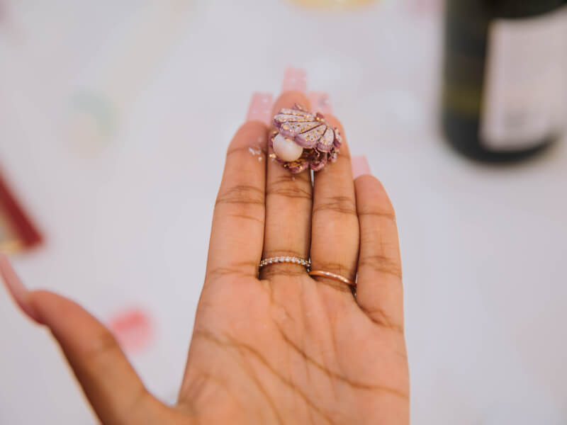 Close up of a person holding a small, seashell-shaped piece of jewellery